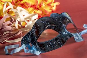 Venetian carnival mask with feathers, and typical elements in the background photo