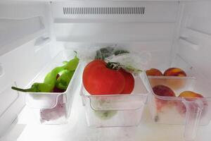 plastic containers with different fruits in a open fridge. photo