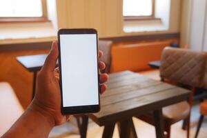 A Smartphone Display Set Against the Backdrop of a Modern Cafe Environment and Atmosphere photo