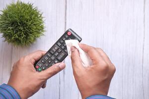 Using a Wipe to Clean the Remote Control for Better Hygiene and Reduced Germ Presence photo