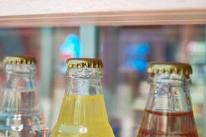 Vintage beverage bottles with colorful caps on bar shelf create a nostalgic retro drinks display photo