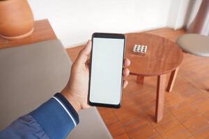 A Hand Gripping a Smartphone While Relaxing in a Stylish and Modern Indoor Environment photo