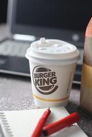 WASHINGTON - USA - August 17, 2024 - Working hard fueled by Burger King A coffee cup and a notebook on a desk, ready for productivity. photo
