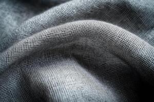 Dark, textured fabric with a rough, woven pattern, creating a rich and tactile surface with deep folds photo