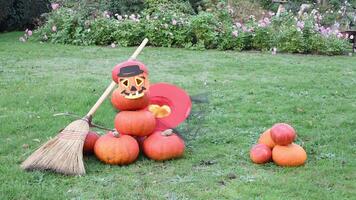 Pumpkin pyramid folded into the shape of a scary scarecrow filled with a creepy Halloween symbol wearing a hat and mask with a broom decoration, the hat falling off the pumpkin head, video