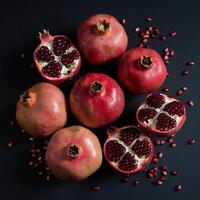 Fresh red pomegranate raw organic fruit for juicy on dark table photo