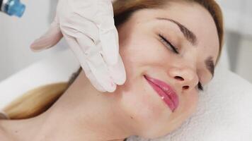 A professional performs a hydropeeling facial treatment on a woman in a modern clinic, focusing on deep skin cleansing and rejuvenation. Perfect for showcasing advanced skincare techniques video