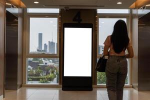 Office hallway with floor stand, LCD screen, liftgate open-close interior realistic empty lobby with elevator, plant and blank advertisement display. photo