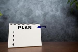 Notebook with action plan and today's stickers on wooden table, to-do list and plan for year. photo