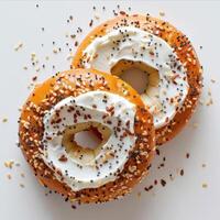 two bagels with frosting and sprinkles on a white photo