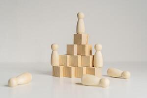 A wooden figure stands on top of three wooden blocks. The blocks are stacked on top of each other photo