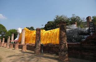 The golden yellow robe covers the white reclining Buddha image at Wat Khun Inthapramun. photo