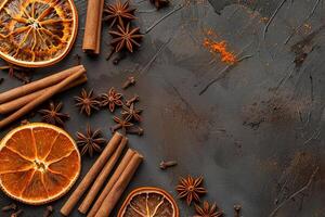 top view composition of cinnamon sticks, dried orange and star anise border frame flat lay template with copy space on left side photo