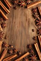 vertical top view border frame of cinnamon sticks and star anise on wooden background flat lay template with copy space photo