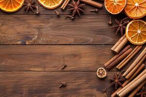 top view composition of cinnamon sticks, dried orange and star anise border frame on wooden background flat lay template with copy space photo