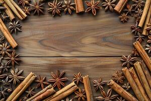 composition of cinnamon sticks and star anise border frame on wooden background top view template with copy space photo