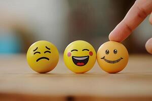 The finger of the hand points to three multi-colored balls with different smiles and emotions photo