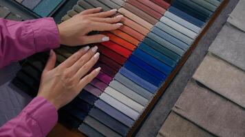 Top view female hands arms touch soft velvet cloth samples eco natural materials in shop woman designer choosing color tone fabric selection colorful catalog textile buying shopping in fashion atelier photo