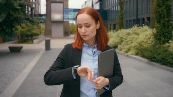 Caucasian businesswoman waiting meeting check time looking at wrist watch business woman wait in city outdoors near office company building sad female manager checking late clock lateness go away photo