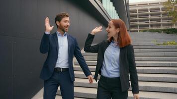 Caucasian business entrepreneurs walk success achievement gesture good idea agreement two people walking in city discuss colleagues coworkers man woman talking give high five smiling happy teamwork photo
