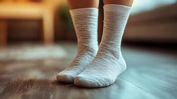 Close up of Swollen Feet with Compression Socks on Wooden Floor photo