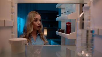 Point of view POV inside refrigerator Caucasian girl hungry woman open fridge at home kitchen look at empty shelves order food products delivery with mobile phone app online service web store shopping photo