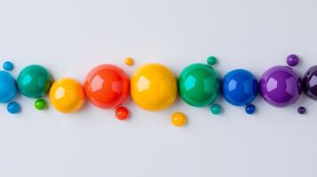 Rainbow colored paint bubbles forming a wave pattern against a light grey background photo