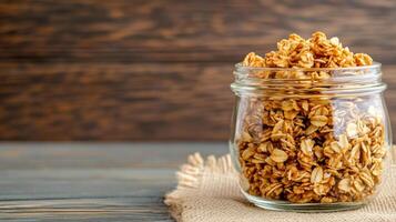 Honey flavored granola in a glass jar with a burlap sack market stall background rustic feel photo