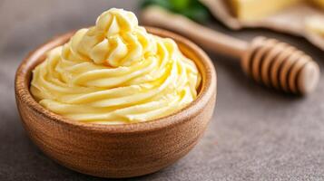 Fresh honey butter in a ceramic dish with a wooden knife on a rustic market stall background photo