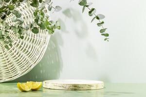 Empty wooden podium with lemon slices on blue background with eucalyptus leave photo