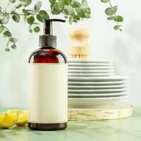 Bottle with dish detergent and clean plates on blue background photo