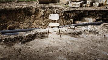 Empty old chair against the background of a break in the scorched earth photo