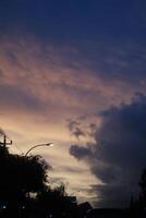 Purple Sky With Clouds And Trees In The Foreground photo