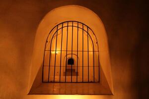 a building and iron windows with white walls and brown lights photo