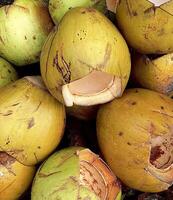 A Bunch Of Coconuts Are Stacked Together In A Large Pile photo