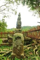 A Large Stone Statue With A Fence In The Background photo