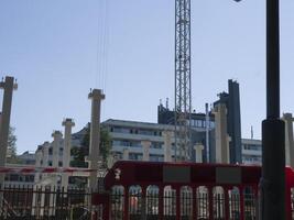 Crane in background working on a building under construction. Building framework visible as crane operate. Construction workers busy at the building site. Building development in progress. photo