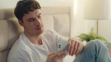 Caucasian European man bed using mobile phone smartphone error broken failure telephone gadget technology guy male notification displeased problem spam internet mistake social networks connect bedroom video
