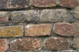 Old brick with inscription O.P. 1899. Part of brick wall. Baltiysk photo