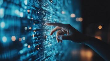 A hand reaches out to interact with a glowing digital interface displaying intricate data patterns in a darkened room photo