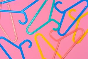 Flat lay composition with empty hangers on pink background photo