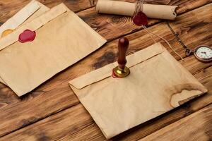 Envelope with wax seal stamp on wooden background, flat lay photo