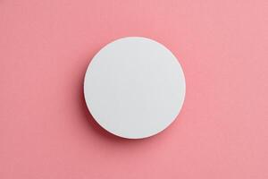 Round White Object Centered on Soft Pink Background photo