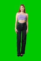 Woman Wearing Black Jeans and a Purple Top Posing in Front of a Green Screen photo