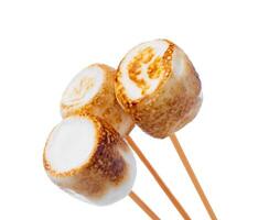 Grilled marshmallows on sticks isolated on white photo
