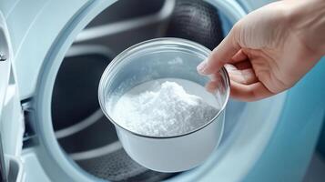 Adding laundry detergent to a modern washing machine during a household chore in a bright laundry room photo