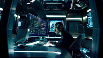 A man is sitting in front of a computer monitor in a room with other monitors video