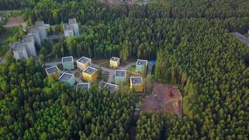 A small area on the edge of the city. Clip.The view from the helicopter is not small houses located next to a green summer forest. video