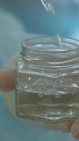 Pouring sterile liquid into the small container in the operating room. Action. Team of medical workers. video