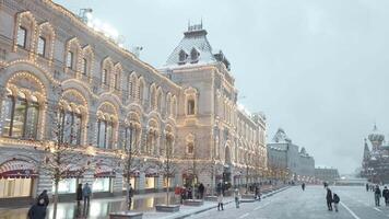 Beautiful city square on a snowy day before the New Year holidays. Action. People walking in front of historic buildings ans temples. video